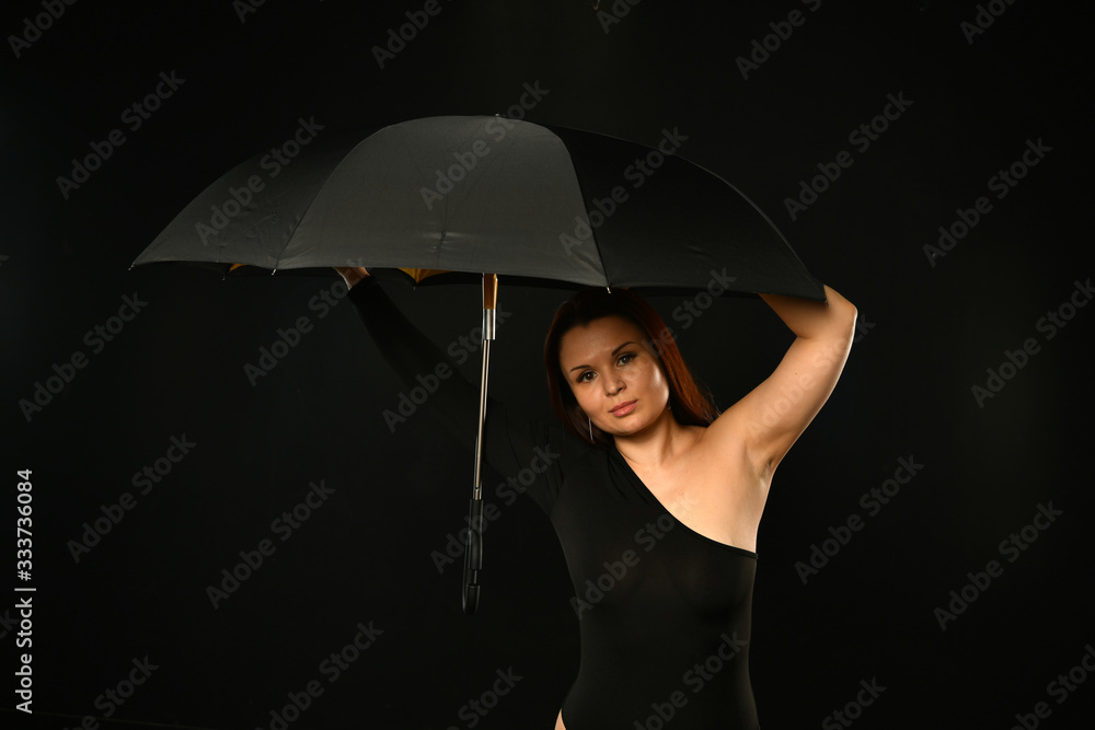 beautiful girl in black with a black umbrella on a black background
