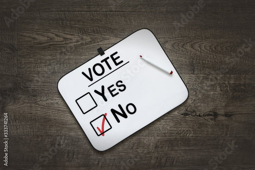 White board with the word Vote,Yes and No Check boxes ,on a dark wooden background