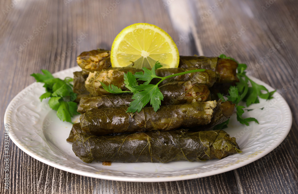 leaf wrap, vine leaf, traditional food, isolated on white, dolmades, sarmale, dolma, lemon slices, appetizer style Meat bean meal.