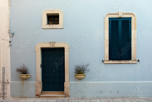 The fachade of a blue old Italian house with green door and windows, Castro, Puglia photo