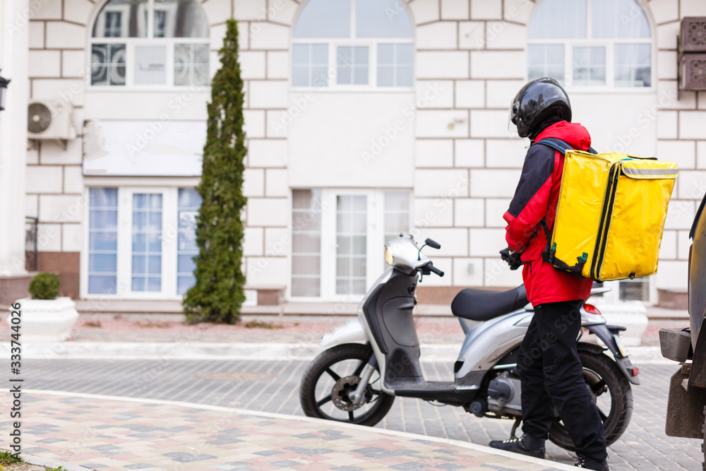 Yellow Delivery Box on Motorcycle with delivery man in front of house. Yellow Delivery Box on Motorcycle with delivery man in front of house.