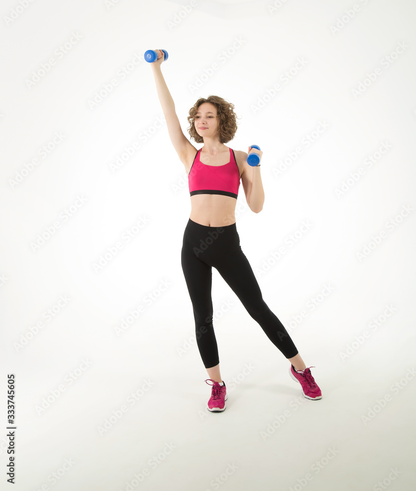 Full length, young athletic woman with dumbbells in her hands doing fitness exercises, standing on a white background. Full length, young athletic woman with dumbbells in her hands doing fitness exercises, standing on a white background.