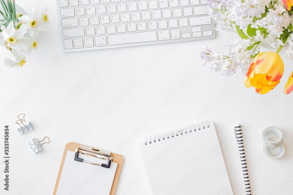 Flat lay blogger or freelancer workspace with a keyboard, yellow tulips and branches of lilac, office supplies on a light background Flat lay blogger or freelancer workspace with a keyboard, yellow tulips and branches of lilac, office supplies on a light background