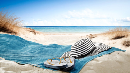 blue towel with hat and summer beach 