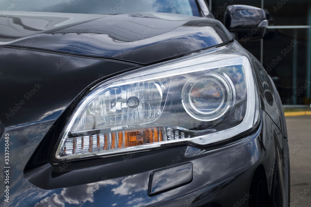 headlight of a black car, concept of the automobile market and the automotive industry, driving lessons and obtaining a driver's license