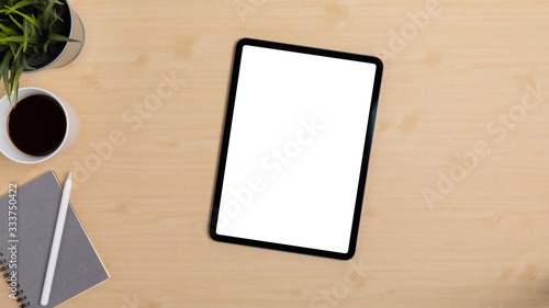 Wooden Table Office desk top view design workspace layout left have plant, coffee cup, pen on top notebook center space show mock up tablet isolated and empty right area for insert text or other