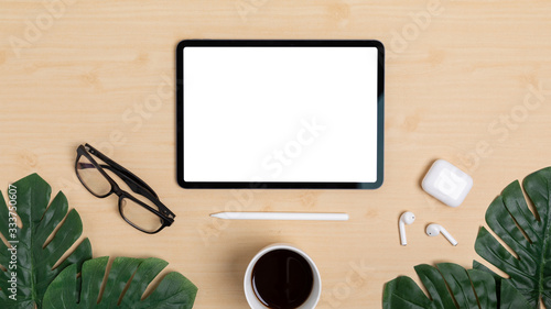Wooden Table Office desk top view design workspace layout center top show mock up tablet isolated for insert on screen under space have leaf, pen, earphones, coffee cup, plant, glasses