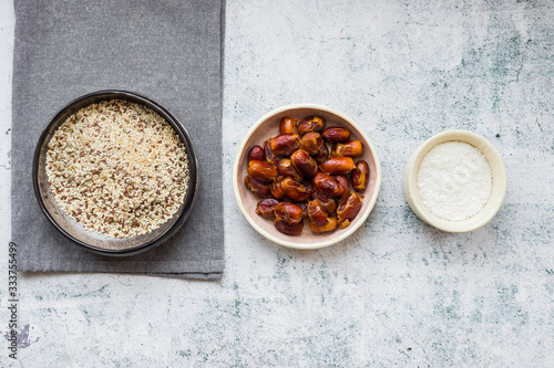 Ingredients for making, preparing sweet balls. Sesame and flax seeds, dates, coconut flakes.
