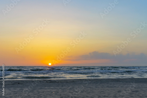 Sunset over the sea. Reflection of sunlight in the sea waves. The sky in the sunset rays.