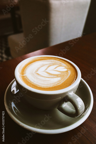 Closeup Coffee latte art leave from fresh milk foam on side of wood