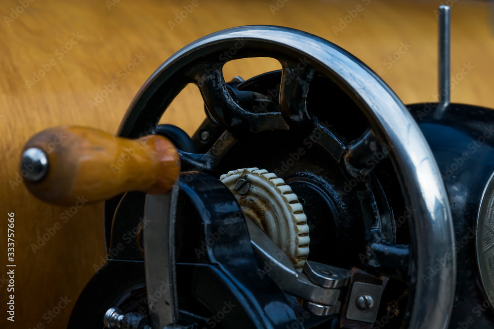 Fototapeta premium Vintage sewing machine. Retro. History of sewing. Cover, elements and details of a sewing machine close-up. Macro photo.