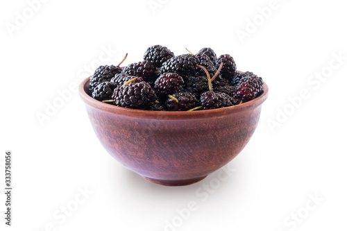 Mulberries in bowl isolated on white background. Black mulberry on white background. Ripe and tasty berry with copy space for text. Sweet and juicy mulberry isolated on white background.