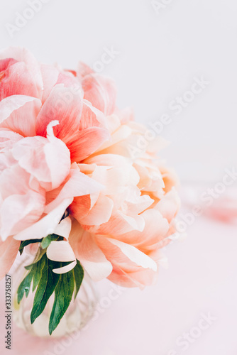 Fresh bunch of pink peonies and roses in a vase on pink background. Card concept, pastel colors, copy space