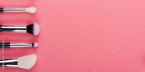Make up brush lie on a pink background