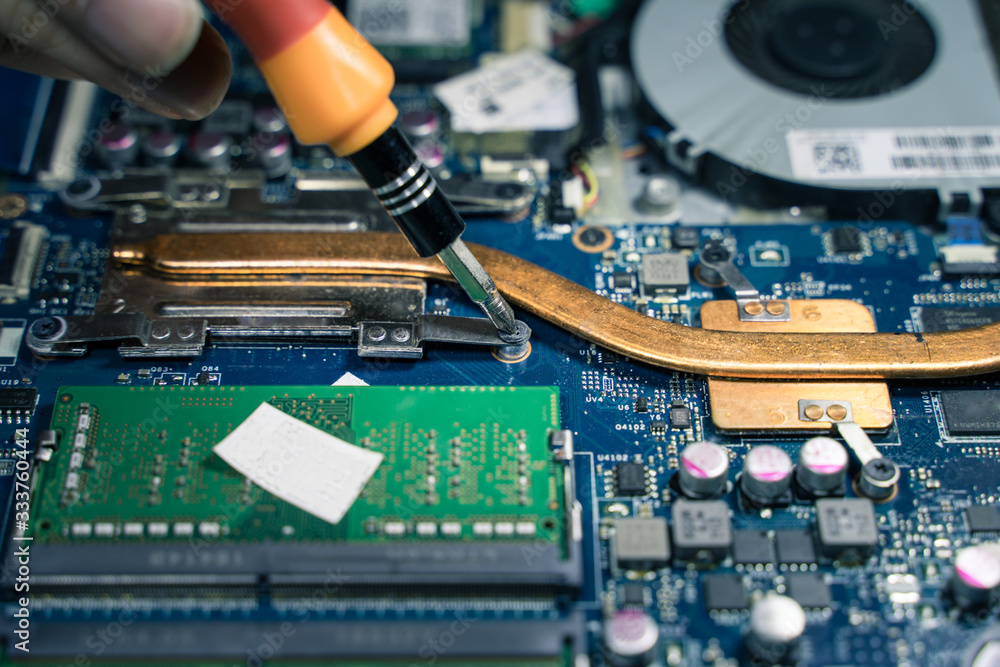 A close-up of an electrician repairing a computer circuit board,close up electrician hands are working with soldering iron A close-up of an electrician repairing a computer circuit board,close up electrician hands are working with soldering iron
