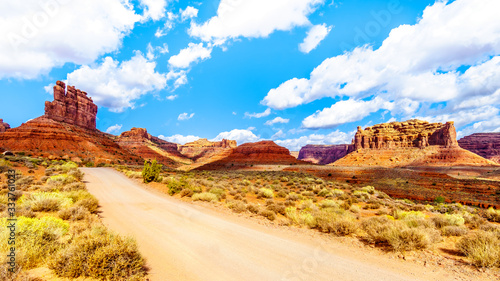 Gravel Road winding through the landscape of Red Sandstone Buttes and Pinnacles in the semi desert landscape in the Valley of the Gods State Park near Mexican Hat, Utah, United States