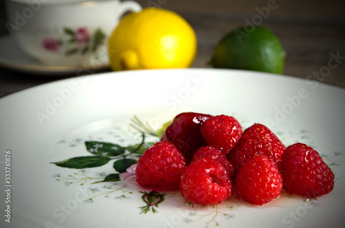 Delicious Red Strawberries and Raspberries with Honey on an Antique Plate