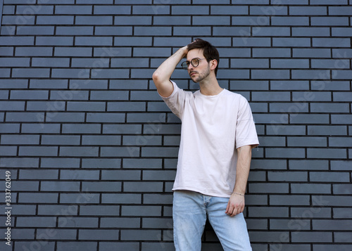 fashion guy poses brick black urban background