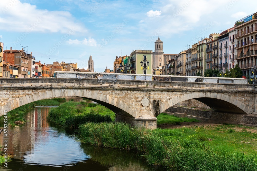 Girona, Spain, August 2018. View of the bridge across the moat and the architecture of the old city.