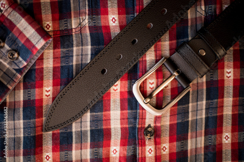 men's black leather trouser belt in the background, men's fashion accessories closet. Genuine leather, handmade belt