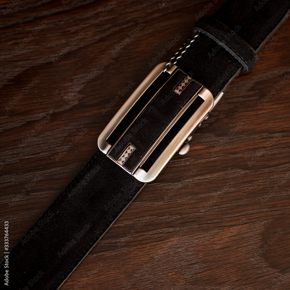 men's black leather trouser belt in the background, men's fashion accessories closet. Genuine leather, handmade belt men's black leather trouser belt in the background, men's fashion accessories closet. Genuine leather, handmade belt