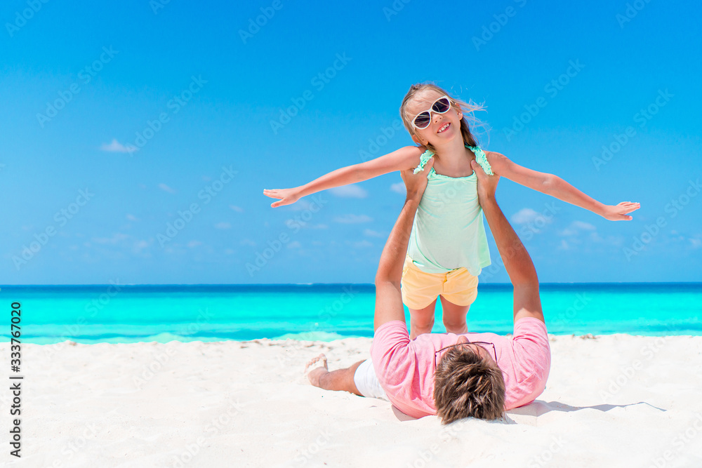 Little girl and happy dad having fun during beach vacation Little girl and happy dad having fun during beach vacation