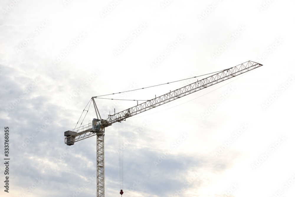 Tower cranes work during the construction of a multi-story building. New apartments for residents and premises for offices. Risky work at height. Lifting heavy building materials. City development Tower cranes work during the construction of a multi-story building. New apartments for residents and premises for offices. Risky work at height. Lifting heavy building materials. City development