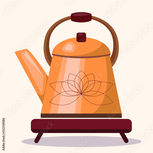 An ethnic Chinese copper coffee pot with an engraved Lotus flower stands on a wooden stand. Simple flat teapot isolated on a light background