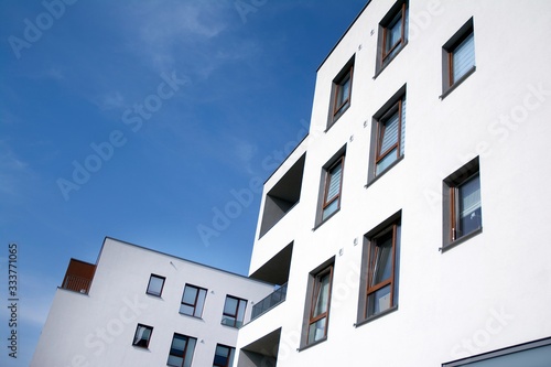 Exterior of new apartment buildings on a blue cloudy sky background. No people. Real estate business concept. © Grand Warszawski