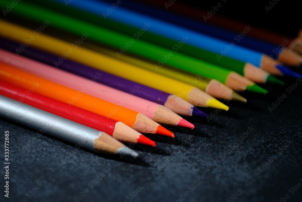 Group of pencils of different colors on a dark textured background Group of pencils of different colors on a dark textured background