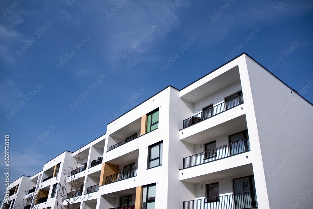 Exterior of new apartment buildings on a blue cloudy sky background. No people. Real estate business concept. Exterior of new apartment buildings on a blue cloudy sky background. No people. Real estate business concept.