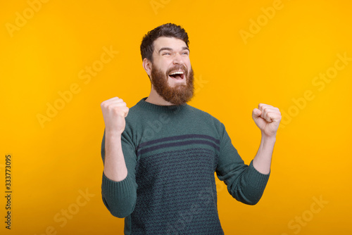 Oh yeah, I got it. Happy bearded guy is making the winner gesture on yellow background.