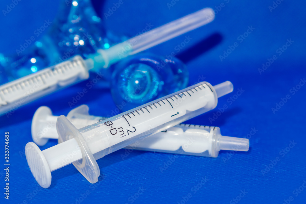 White 2 ml syringes macro on blue vibrant surface White 2 ml syringes macro on blue vibrant surface