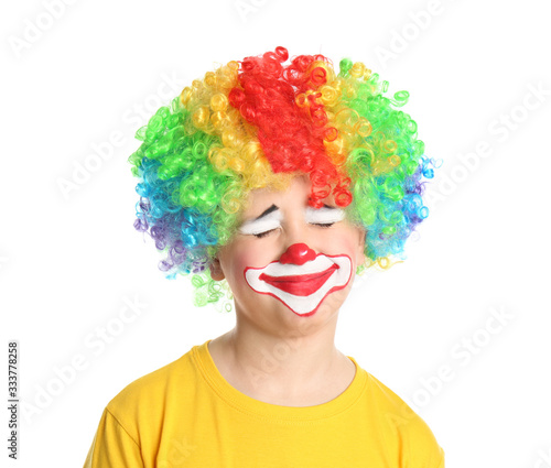 Preteen boy with clown makeup and wig on white background. April fool's day