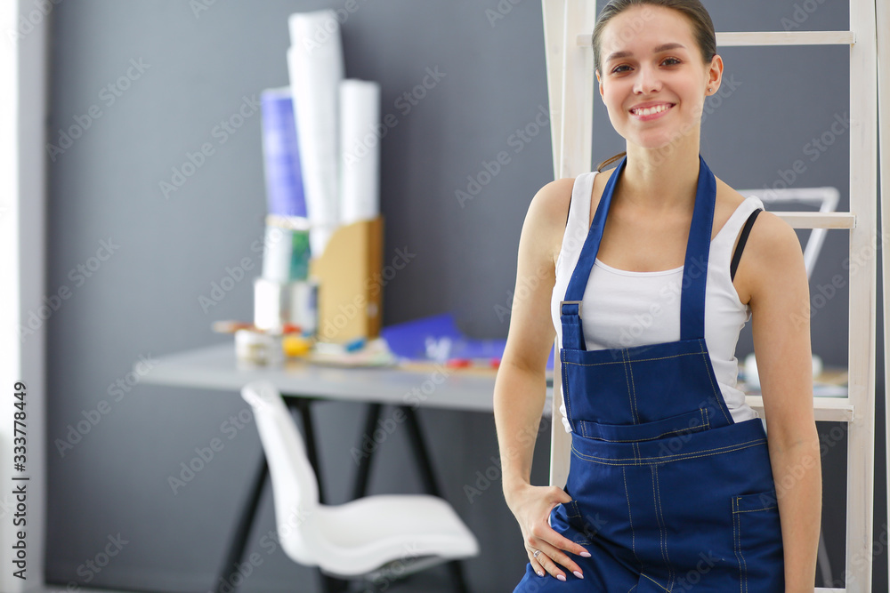 Worker woman with drill standing in new home.