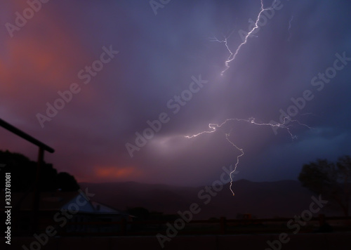 Lightning emanates in all directions from stormy sunset sky