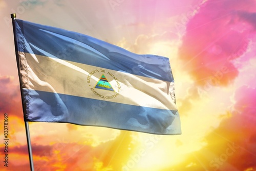 Fluttering Nicaragua flag on beautiful colorful sunset or sunrise background. Success concept.