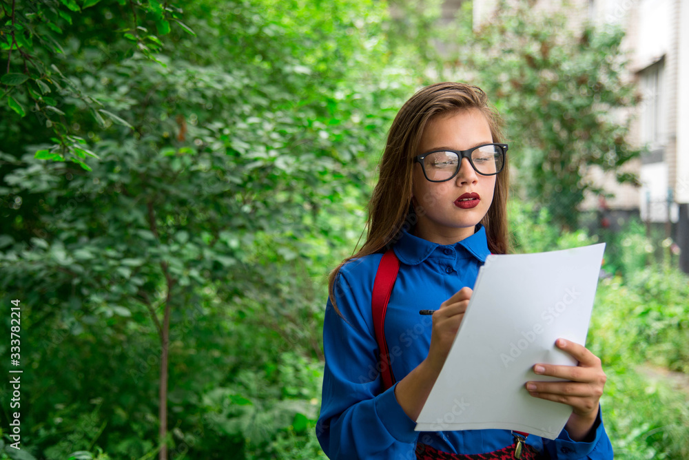 The young writer looking for inspiration for a walk. Stylish girl with leaves in their hands. The young writer looking for inspiration for a walk. Stylish girl with leaves in their hands.