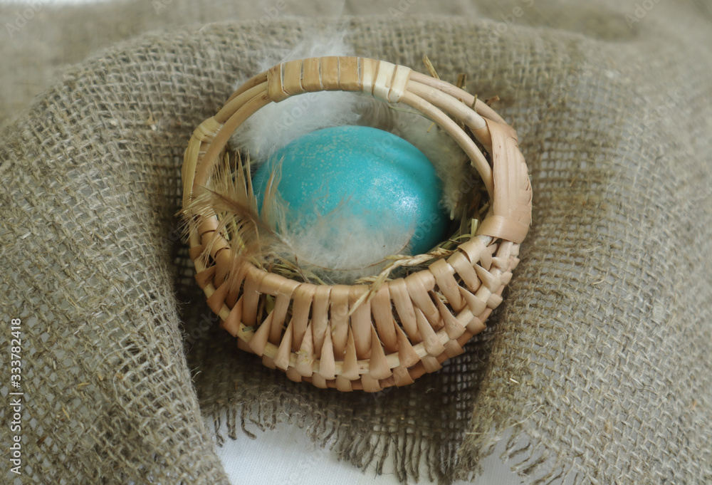 Painted egg in a basket on sacking Painted egg in a basket on sacking