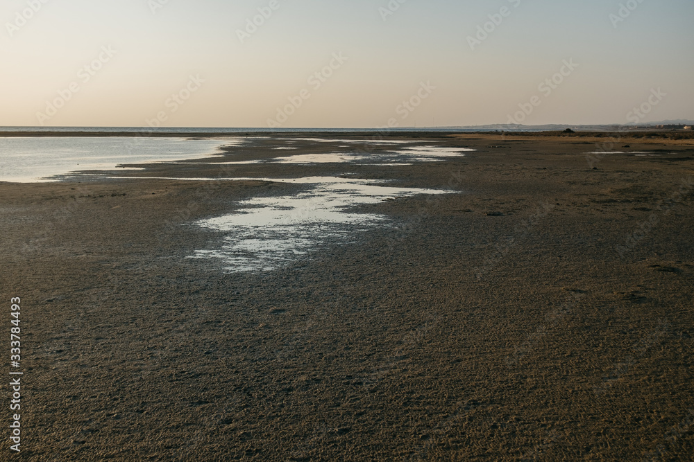 Empty beach with wet sand in the evening