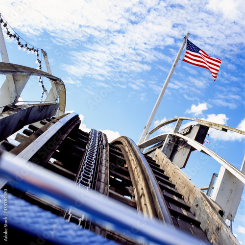 Rollercoaster with American US flag and sky. Risk, volatility, instability, up and down concepts. Motion blur effect.