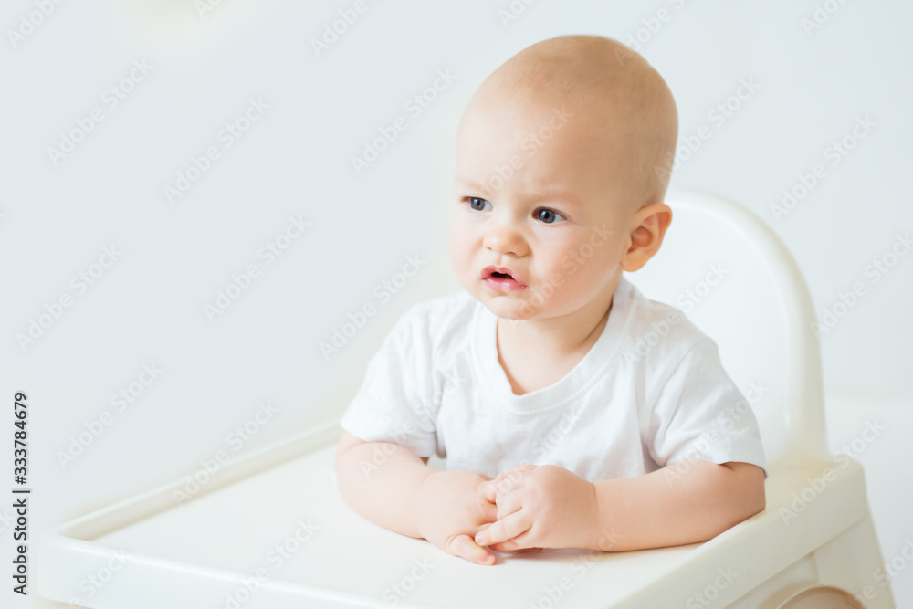 Portrait of a cute baby boy smiling sitting at the table looking at the camera Portrait of a cute baby boy smiling sitting at the table looking at the camera