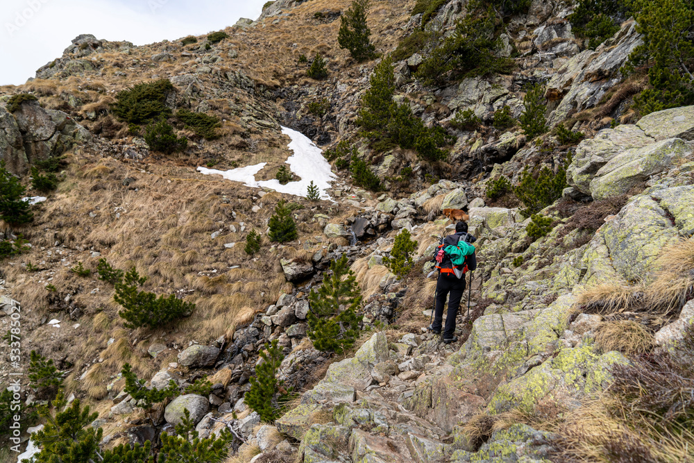 Hiker woman with her dog in National Park of Aigüestortes and lake of Sant Maurici.