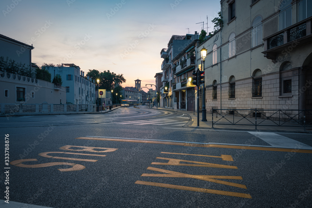 Fototapeta premium Padua, sunset in a city center street along the tram rails, long exposure, Italy