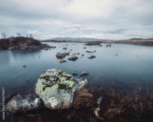 A mountain lake in the Scottish Highlands with stones in the water. This lake Lochan na h-Achlaise is on the road through Glen Coe, Scotland photo