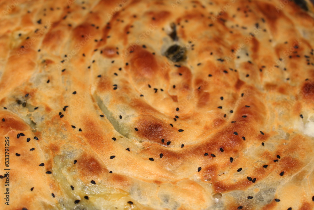 Famous Turkish pastry (Turkish borek) with spinach and black cumin on top. Famous Turkish pastry (Turkish borek) with spinach and black cumin on top.