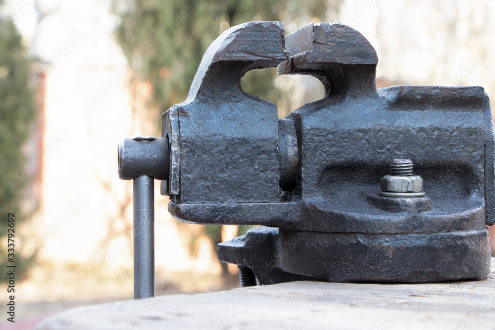 Old vise on a wooden bakground. Old instrument.