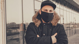 Men wears a black protective medical face mask being in the city during a coronavirus pandemic. Protection from viruses in the city.