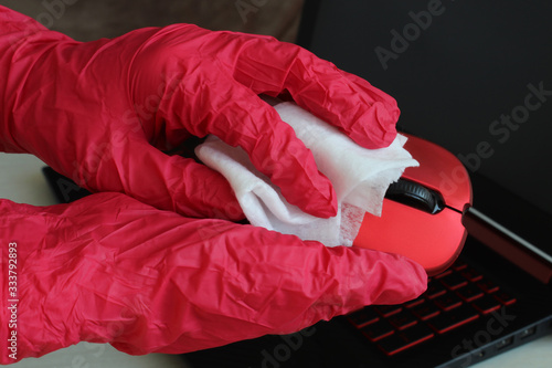 Disinfection of your workspace, the fight against the virus, coronavirus COVID-19. A female hand wipes a computer mouse disinfecting wipes. photo