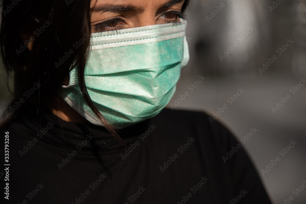 Corona - Covid-19 conceptual image of a sad woman wearing a face mask